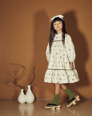 Fille portant la robe crème à fleurs et ruban vert