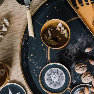 Sous-verres Astrology en métal doré signés Boncoeurs, créations artisanales inspirées des signes du zodiaque, disponibles chez la boutique Coton en Herbe.