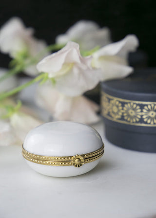 Pilulier en porcelaine de Limoges serti laiton, signé Alix D. Reynis, conçu pour accueillir des recharges d’onguent.